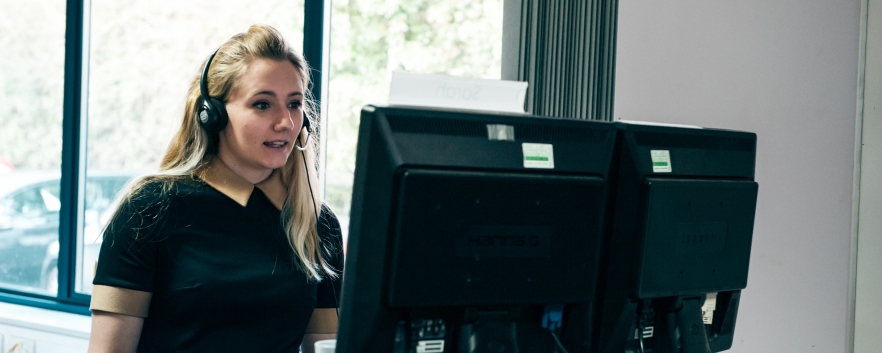 Person with headset looking at computer screen
