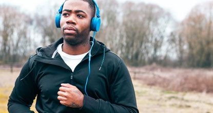 Man with headphones listens to a webinar while out running