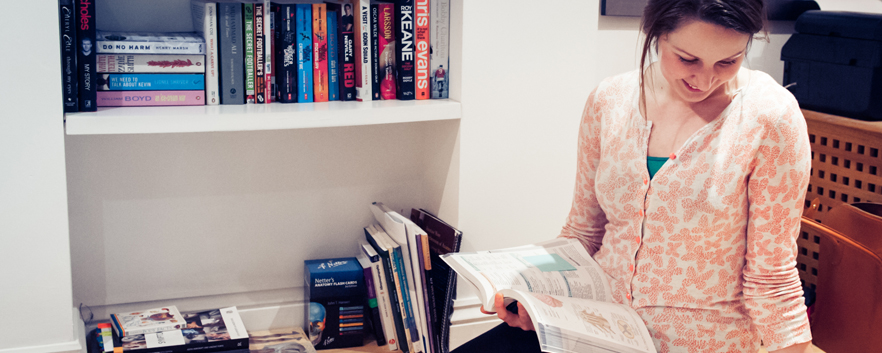 Person smiling with book in hand