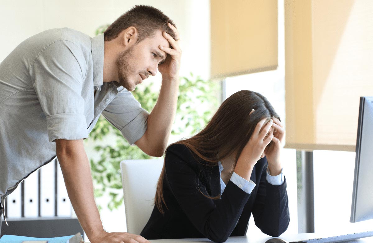 Man and woman looking concerned at their computer screen