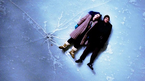 Man and Woman in winter clothes laying on ice that has a crack in it