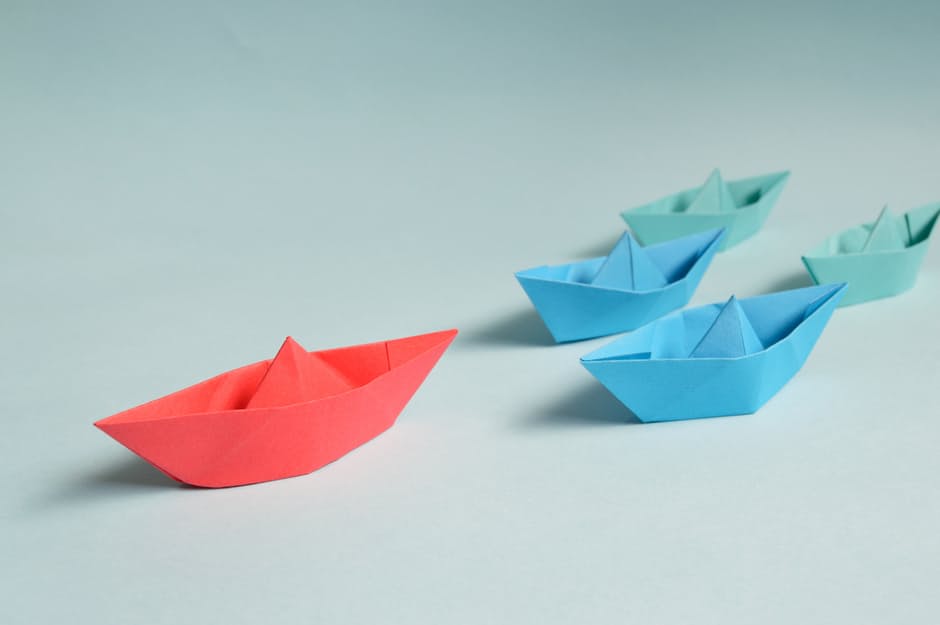 Five different coloured origami boats