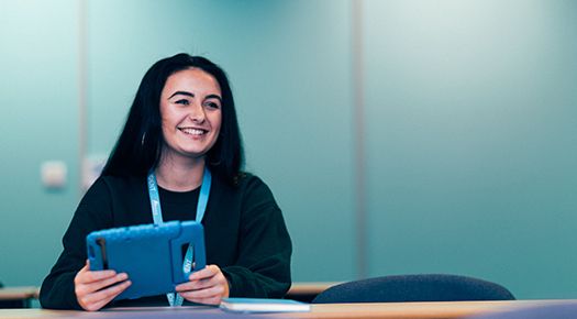Woman smiling and holding a tablet