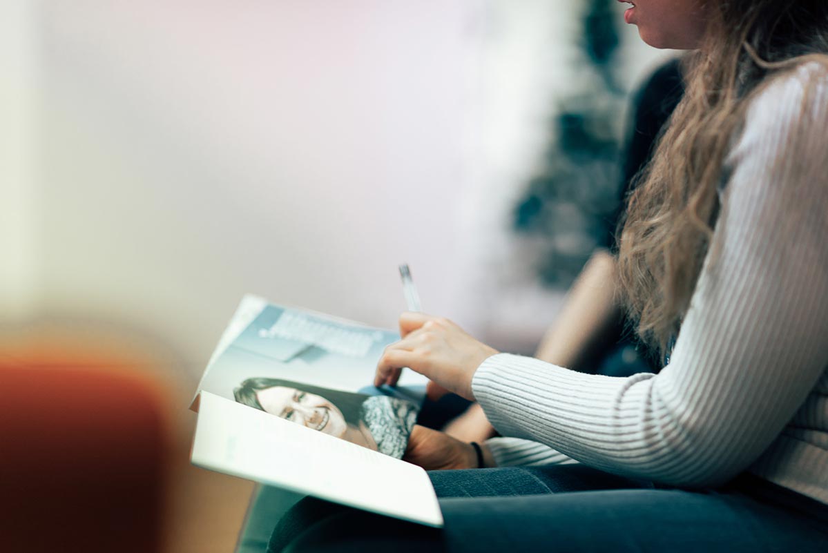 Woman looking at a book in her lap